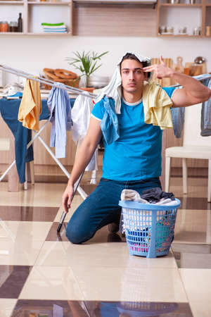 Young man husband doing clothing ironing at homeの写真素材