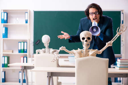Male teacher and skeleton student in the classroomの写真素材
