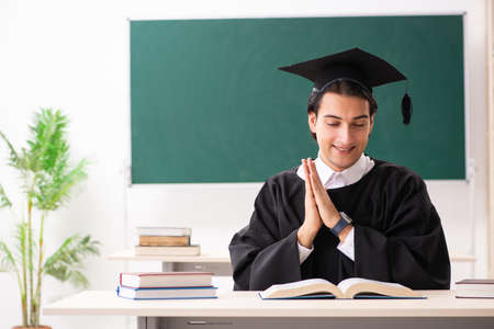 Graduate student in front of green boardの販売画像