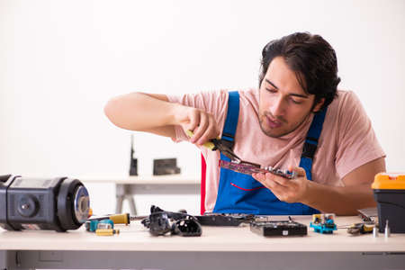 Young male contractor repairing computerの写真素材