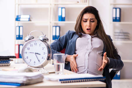 Young pregnant woman working in the officeの写真素材