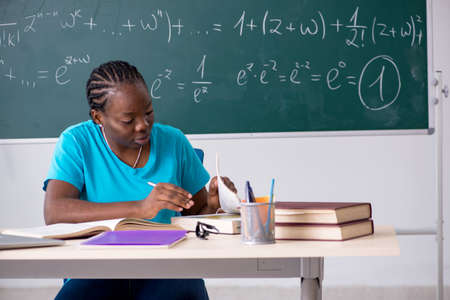 Black female student in front of chalkboardの写真素材