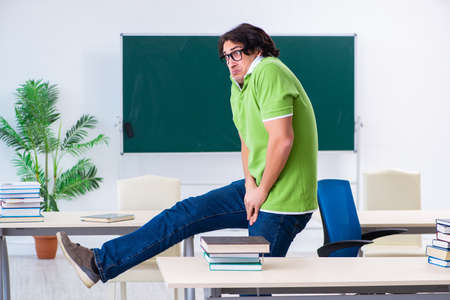 Male student suffering from urge in the classroomの写真素材