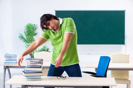 Young male student in front of green boardの写真素材