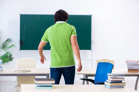 Young male student in front of green boardの写真素材