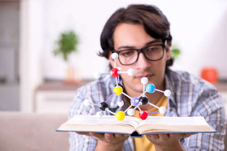 Young student physicist preparing for exam at homeの写真素材