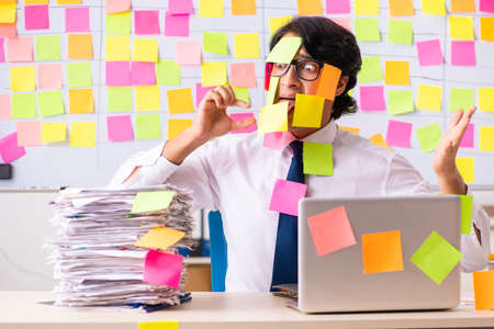 Young employee in conflicting priorities conceptの写真素材