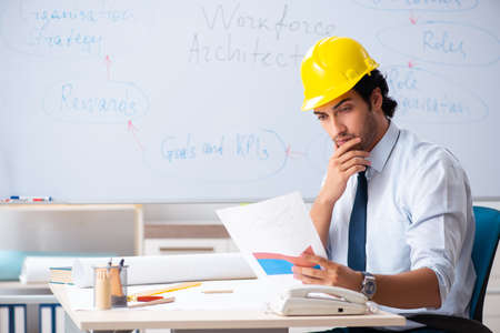 Young male architect in front of the whiteboard