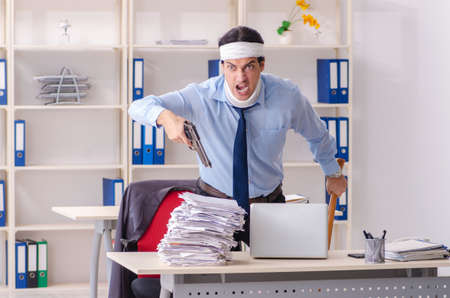 Young injured male employee working in the officeの写真素材