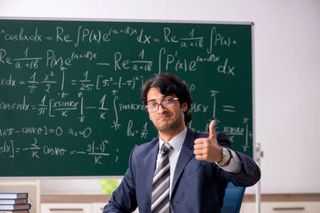 Young male math teacher in classroomの写真素材