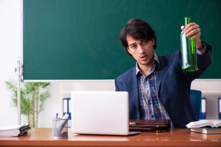 Male teacher drinking in the classroomの写真素材