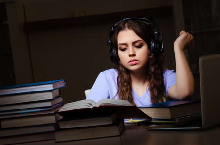Young female student preparing for exams late at home
