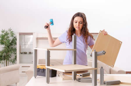 Young woman repairing chair at homeの写真素材