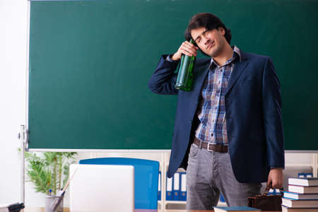 Male teacher drinking in the classroomの写真素材