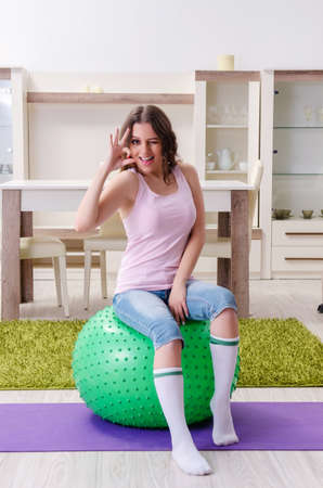 Young beautiful woman doing exercises at homeの写真素材