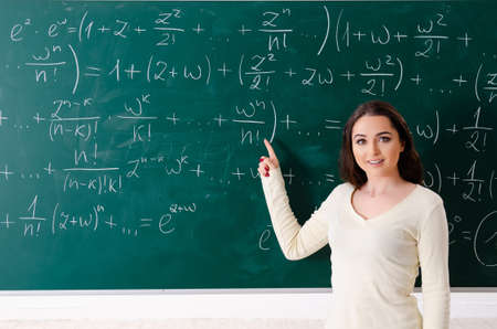 Young female math teacher in front of chalkboard