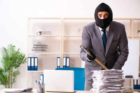Male gangster stealing information from the officeの写真素材