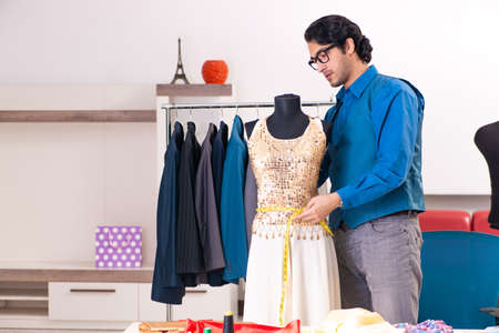 Young male tailor working at workshopの写真素材