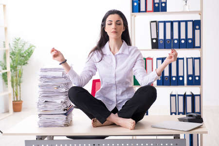 Young female employee doing exercises in the officeの写真素材
