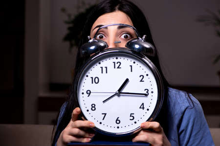 Young female student preparing for exams at night timeの写真素材