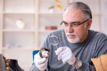 White bearded old jeweler at workshop