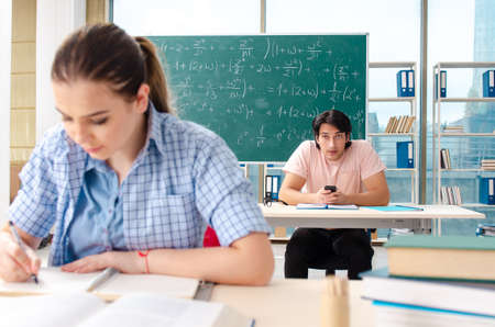 Young students taking the math exam in classroom