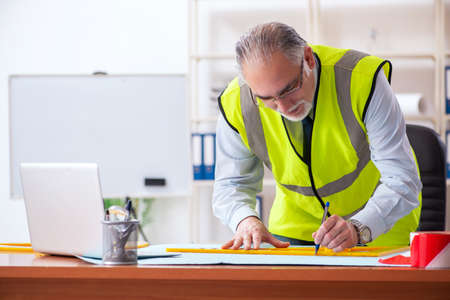 Aged construction engineer working in the office