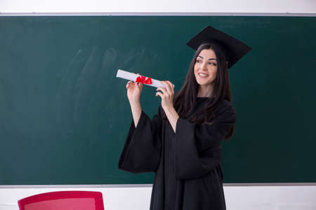 Female graduate student in front of green board