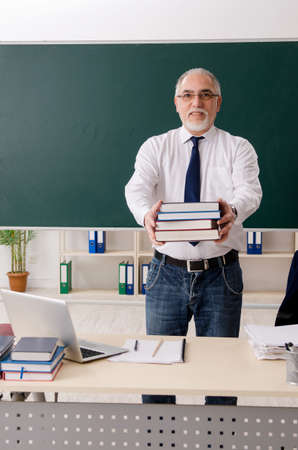 Aged male teacher in front of chalkboardの写真素材