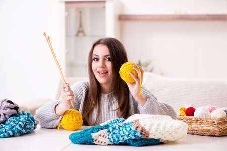 Young beautiful woman knitting at homeの写真素材