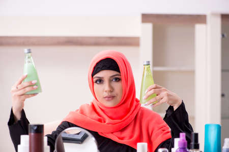 Beautiful woman in hijab applying make-upの写真素材