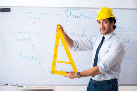 Young male architect in front of the whiteboardの写真素材