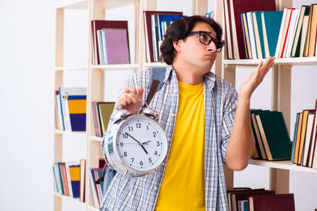 Male student preparing for exams at libraryの写真素材