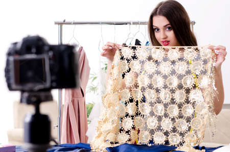 Young beautiful female tailor recording video for her blogの写真素材