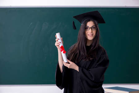 Female graduate student in front of green boardの写真素材