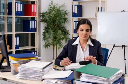 Female employee with too much work in the officeの写真素材