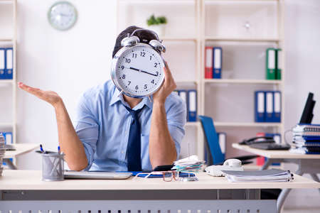 Young male businessman employee unhappy with excessive workの写真素材