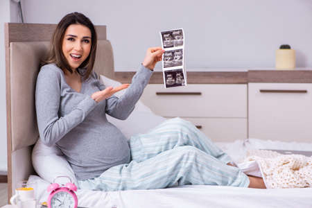 Young pregnant woman in the bedroomの写真素材
