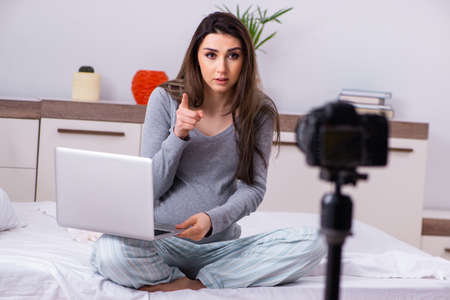 Pregnant woman recording video for her blog