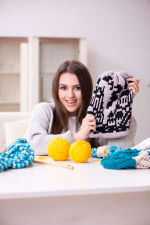 Young beautiful woman knitting at home