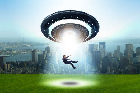 Flying saucer abducting young businessmanの写真素材