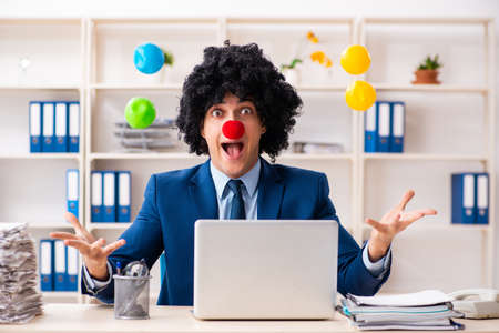 Young clown businessman working in the officeの写真素材