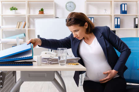 Old pregnant woman working in the officeの写真素材