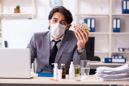 Man with flu working in the officeの写真素材