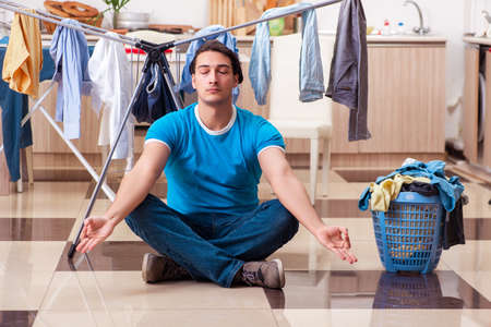 Young man husband doing clothing ironing at homeの写真素材