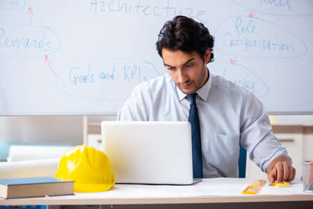 Young male architect in front of the whiteboard