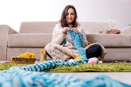 Young beautiful woman knitting at homeの写真素材