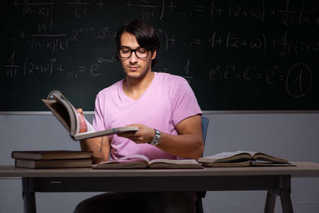 Young male student sitting in classroomの写真素材