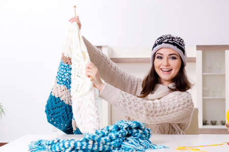 Young beautiful woman knitting at home