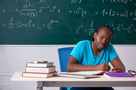 Black female student in front of chalkboardの写真素材